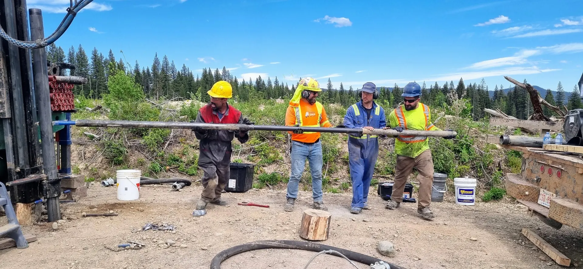 Drill crew handling a drill rod on an exploration site
